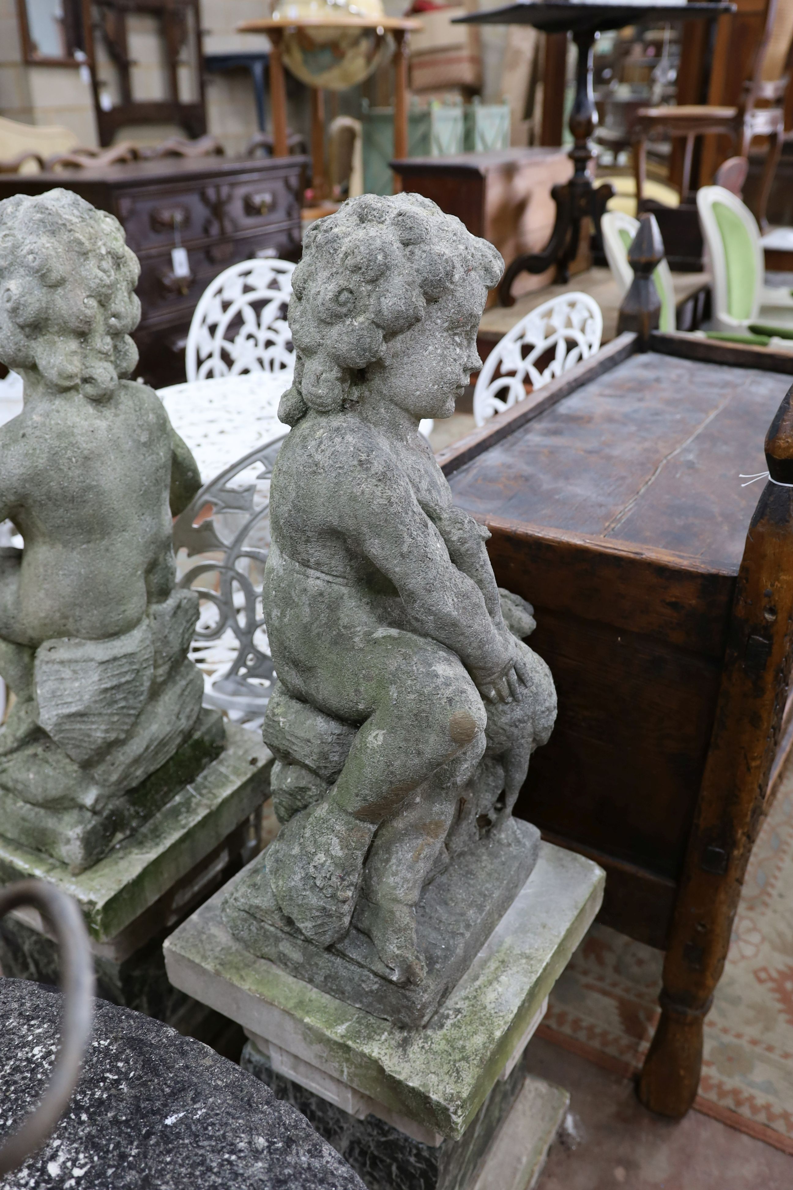 A pair of reconstituted stone cherub and dove garden ornaments on faux marble plinths, height 116cm